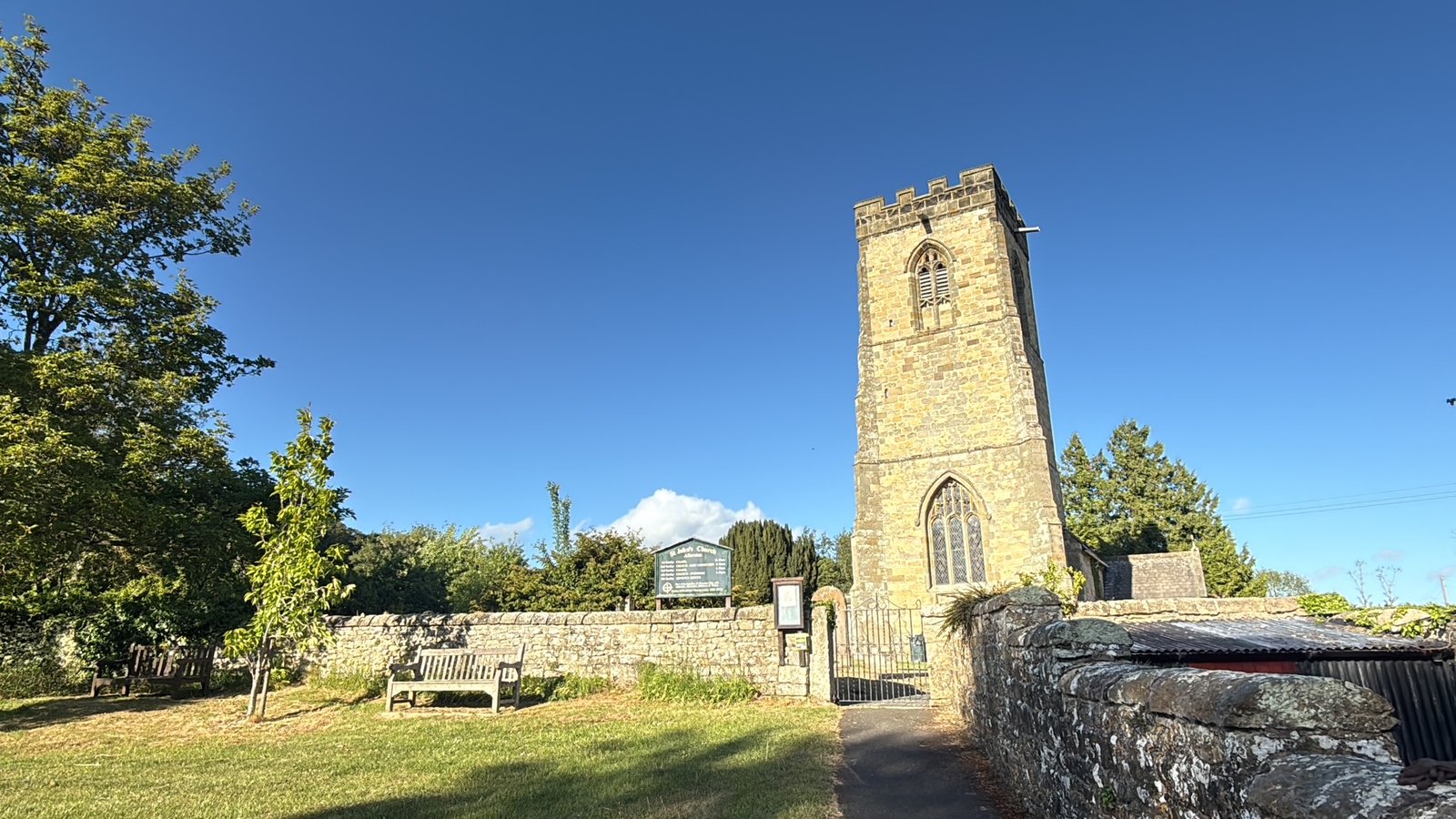 The Allerston parish church tower against a clear blue sky